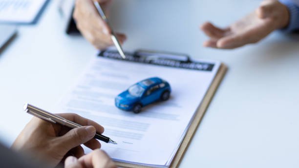 Person signing a car finance agreement document