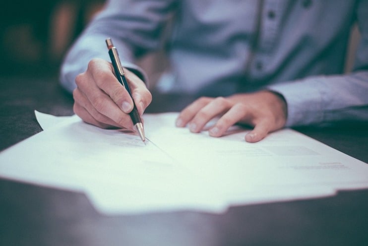 Person writing a formal dispute letter at a desk